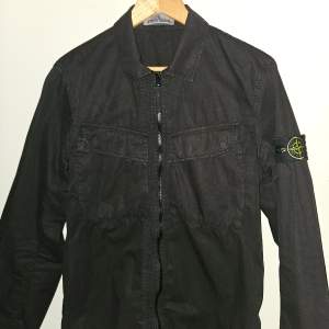 Stone Island overshirt jacka från förra årets sommar kollektion. Helt ny i 10/10 skick, tunn jacka perfekt för sommarkvällar. Säljes endast för 3000 kr, ny pris ca 4500 kr. Original så klart med alla taggar osv. 