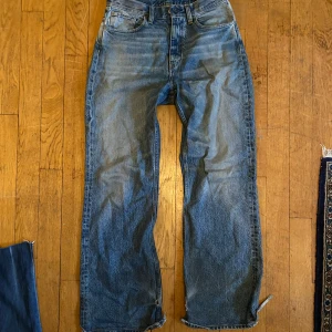 Blå jeans från Hope - Säljer ett par snygga blå jeans från Hope. De har en avslappnad passform med en bred bootcut-stil. Jeansen är i en klassisk blå tvätt och har en hög midja. Perfekta för en casual look eller att klä upp med en snygg topp. De är i använt skick med lite defekter och därav priset!👍