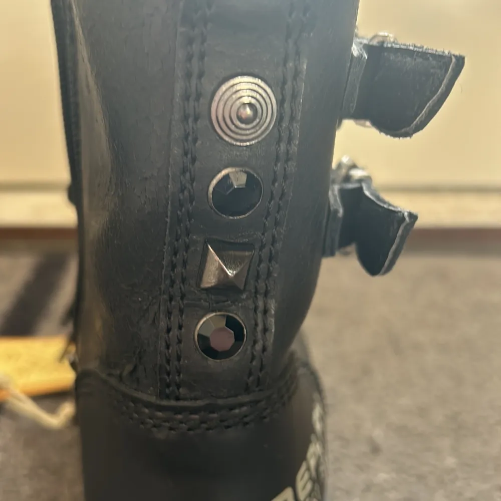 Säljer ett par svarta boots från Replay i nyskick. De är gjorda av polyster och har coola detaljer som nitar och snörning. Bootsens sula är robust och mönstrad för bra grepp. Perfekta för höst och vinter!. Kengät.