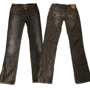 Jeans från Big Star - Säljer ett par snygga jeans från Big Star. De är svarta med coola kontrastsömmar i gult och rött på bakfickorna. Jeansen är bootcut och med en bekväm passform. Perfekta för vardagsbruk!