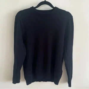 Marinblå tröja från These Glory Days - Säljer en stilren svart tröja från These Glory Days i Superior Merino. Perfekt för både vardag och fest. Tröjan har långa ärmar och en klassisk passform. Supermjuk och bekväm!