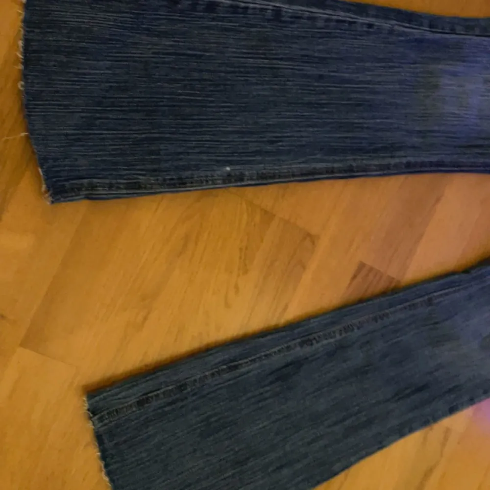 Säljer ett par snygga blå jeans från J. Galt i storlek S. De är tillverkade av 99% bomull och 1% elastan, vilket gör dem både bekväma och stretchiga. Jeansen har en klassisk design med en straight passform och låg midja. Perfekta för vardagsbruk ell. Jeans & Byxor.