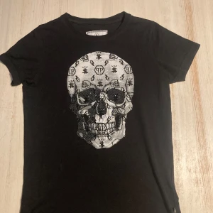 Philipp Plein T-shirt  - Snygg tröja från Philipp Plein tröja köpt på kids brandstore!  - Den har förlorat några ”stenar” på dödskallen men inget man lägger märke till. Har en röd fläck på sleeven som förmodligen går bort i tvätten. Size Junior… 