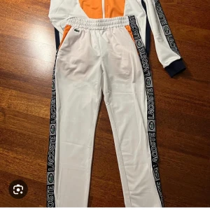 Lacoste sport tracksuit - En fräsh Lacoste dress, äkta såklart inköpt på thernlunds och zalando. Tröjan från thernlunds och byxan från zalando. Va tvungen att göra så då strl på byxan fanns inte på zalando. Strl är M-L och användes ca 3-4 ggr Max. För stor på mig.