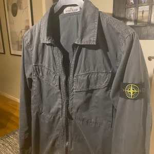 Stone island overshirt  - Säljer nu min riktigt fet overshirt då den inte kommer till användning lika mycket längre, den är i ett väldigt fint skick, den är köpt i färgen grå men i verkligheten så är den lite grå och grönaktig i färgen vilken är en väldigt snygg färg