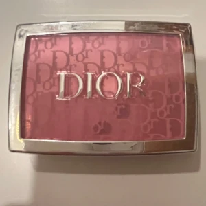Dior Rosy Glow Blush 001 Pink - Säljer en superfin Dior Rosy Glow Blush i färgen 001 Pink. Den ger en naturlig och hälsosam lyster till kinderna. Kompakt och lätt att ta med i väskan. Perfekt för att fräscha upp looken under dagen!
