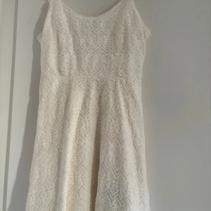 Vit spetsklänning från Abercrombie Kids - Säljer en superfin vit spetsklänning från Abercrombie Kids i storlek KIDS L. Klänningen har ett vackert spetsmönster och är ärmlös, perfekt för sommarens alla fester. Den har en normal passform och är gjord i ett mjukt och bekvämt material. Passar både till vardag och festliga tillfällen! Köparen betalar frakt. 