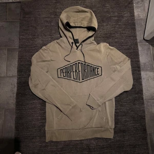 Mörkgrön hoodie från Peak Performance - Säljer en snygg mörkgrön hoodie från Peak Performance i storlek S. Den har en stor logga på bröstet och är supermjuk inuti med fleecefoder. Perfekt för kyliga dagar och har en klassisk känguruficka framtill. Passar både till vardags och chillkvällar. 🧥✨