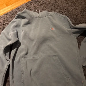 Grå hoodie från Dickies - Säljer en grå hoodie från Dickies i bra skick. Den har en klassisk design med en stor ficka framtill och en liten logga på bröstet. Perfekt för en avslappnad stil och passar till alla årstider. Skön och enkel att matcha med andra plagg.