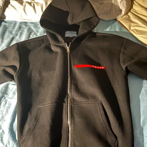 Prada Zip hoodie - Prada zip hoodie till salu , Storlek M passar bra i passform , luvan är riktigt skön, (inget kvitto) Storleken kan både va till M-S  Pris kan diskuteras , (inga byten) Om ni har fler frågor eller funderingar skriv till mig svarar alltid snabbt!!