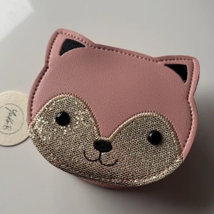 Rosa axelväska i form av en räv för barn - Supergullig rosa axelväska i form av en räv med glittriga detaljer. Perfekt för att bära småsaker och ge en lekfull touch till din outfit. Väskan har en dragkedja och justerbar axelrem. För barn