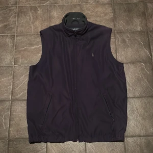 Ralph Lauren väst - Marinblå väst från Polo Ralph Lauren Golf i storlek M. Nypris för västen ligger runt 1500 kr, jag lägger ut den för 400kr! Dragkedjan är lite skadad men det påverkar inte funktionen.