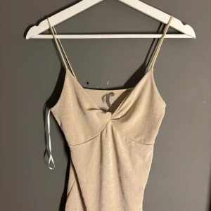 Champagnefärgad klänning från Pieces - Snygg champagnefärgad klänning från Pieces i ett glittrigt material.. Perfekt för festliga tillfällen! ✨