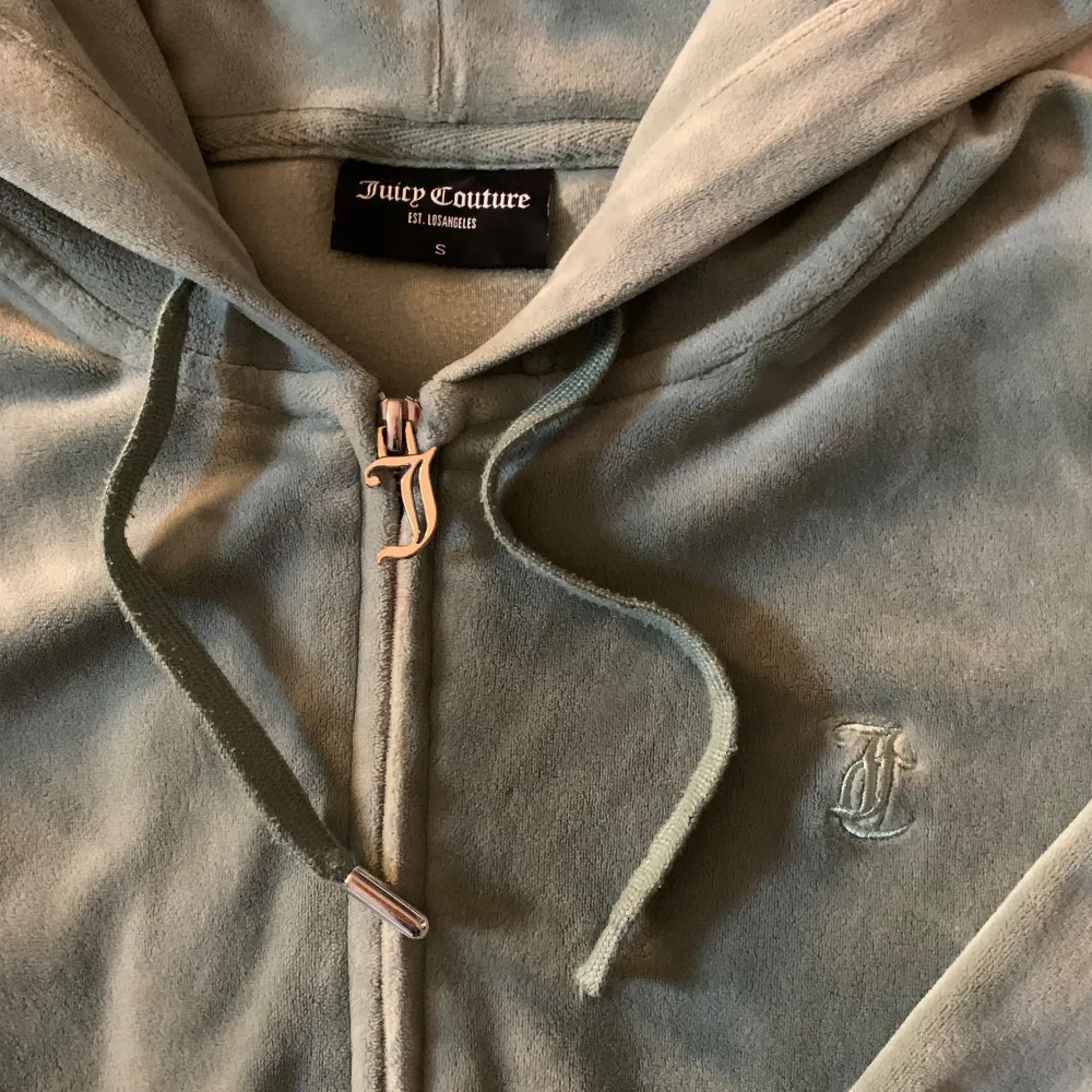 Mysig mintgrön hoodie från Juicy Couture. Den har en dragkedja framtill och en praktisk huva med snören. Som ni ser på bild 2 så e den ena metall biten tyvärr sönder på ena snöret därav priset. Nypris 1200.. Tröjor & Koftor.