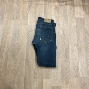 Blå jeans från Replay - Säljer ett par snygga blå jeans från Replay. De har en klassisk femficksdesign med snygga detaljer på bakfickorna. Jeansen är i bra skick och har en normal passform. Perfekta för både vardag och fest! Nypris 2000 vårat pris 349 priset kan diskuteras 