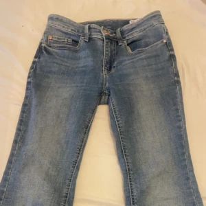 Blå bootcut jeans - Säljer ett par blå bootcut jeans i strl 30, midwaist. Bekvämt material. Säljer för de är lite förstora och kommer inte till användning