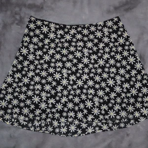 Svart blommig kjol - Svart kjol med vita blommor. Den är använd vid enstaka tillfälle.