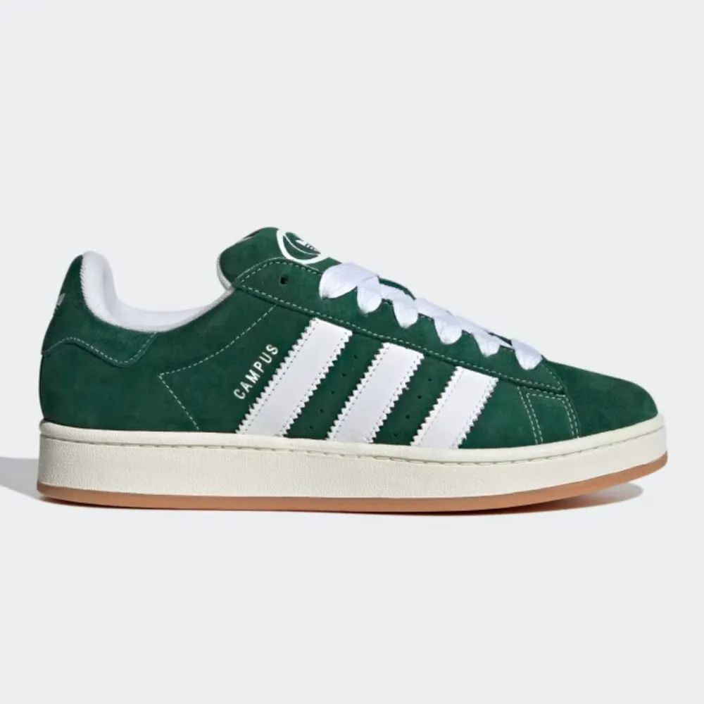 Säljer ett par snygga gröna Adidas Campus sneakers i mocka. De har de klassiska vita tre ränderna på sidan och en bekväm gummisula. Perfekta för både vardag och fest! Skorna är i nytt skick och kommer i originalkartong.. Skor.