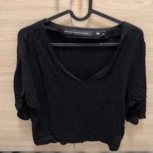 Svart topp från Lager 157 - Snygg svart topp från Lager 157 i storlek S. Den har en v-ringad design och korta ärmar. Toppen är i bra skick.