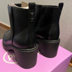 Svarta boots med klack - Snygga svarta boots i skinn med en robust klack. De har en dragkedja på sidan för enkel på- och avtagning. Perfekta för höst och vinter, och funkar lika bra till vardags som till fest. Stilrena och bekväma att gå i! ( dom är helt oanvända ) med spray skydd på också! 