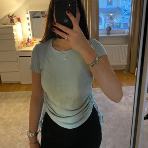 Ljusblå ribbad topp🩵 - Säljer en ljusblå ribbad topp i mycket bra skick. Den har korta ärmar och en snygg snörning på sidan som ger en cool effekt. Perfekt för både vardag och fest! 🤍
