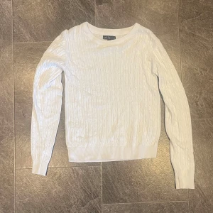 Vit stickad tröja från XOXO Friends - Säljer en superfin vit stickad tröja från XOXO Friends. Den har ett klassiskt flätmönster och är perfekt för både höst och vinter. Tröjan är långärmad och i mycket bra skick. Perfekt för att hålla sig varm och stilren! ❄️