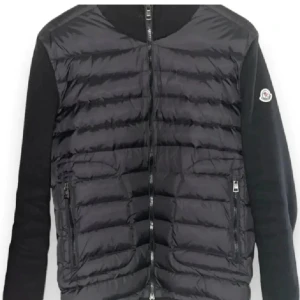 Navy jacka från Moncler - Säljer en stilren svart jacka från Moncler med quiltad framsida och långa ärmar. Jackan har dragkedja och Moncler-logga på ärmen. Perfekt för kyligare dagar.
