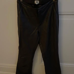 Mörk bruna läderbyxor från Twist & Tango - Läderbyxorna har en rak passform med en medelhögmidja. Tilllverkade i ett material som ger en elegant look. Perfekta för en chic och modern stil. 