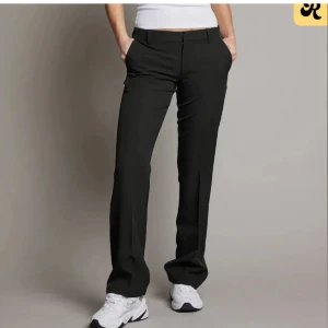 Svarta kostymbyxor - Snygga svarta kostymbyxor med en klassisk design. Byxorna har en låg midja, alltså modellen Vera. Byxorna har lite slitningar nertill, skicka privat för fler bilder!