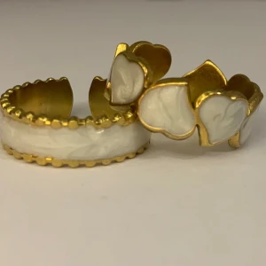  Guldpläterad ring med hjärtan set of two - Charmig guldpläterad  ring dekorerad med vita hjärtan. Ringen har en justerbar design med en fin kantdetalj. Perfekt för att ge en romantisk touch till din stil.