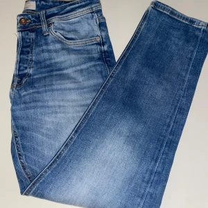 Jack & Jones Jeans - Snygga blå jeans från Jack & Jones i modellen Tapered/Mike. Älskar dessa jeansen, men har tyvärr växt hur dem. De har en perfekt passform och har en riktigt snygg färg. De är snyggt färgade och passar till till nästan allt.                            Ny pris: 900kr, mitt pris 599kr. Priset går att diskutera i dm😊🙌Skick: 9/10 // DeLuxe Resells   (Kan skicka flera bilder då färgen ser mycket bättre ut i verkligheten)