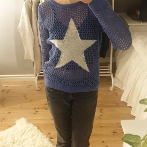 Blå stickad tröja med stjärna - Säljer en blå stickad tröja med ett stort vitt stjärnmönster på framsidan. Tröjan har en luftig stickning och långa ärmar💞💞