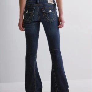 Mörkblå bootcut jeans - Snygga mörkblå bootcut jeans med dekorativa sömmar på bakfickorna. Perfekta för en avslappnad stil med en touch av retro. De har en lågmidjad passform och klassisk femficksdesign. Är sällan använda eftersom dom är lite stora på mig och det därför som jag säljer dom.💗