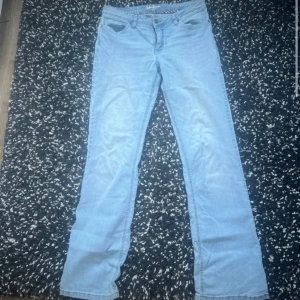 Ljusblå jeansbyxor - Snygga ljusblå jeansbyxor med klassisk femficksdesign. De har en utsvängd passform och är perfekta för en avslappnad stil. Byxorna har en knapp och dragkedja framtill.