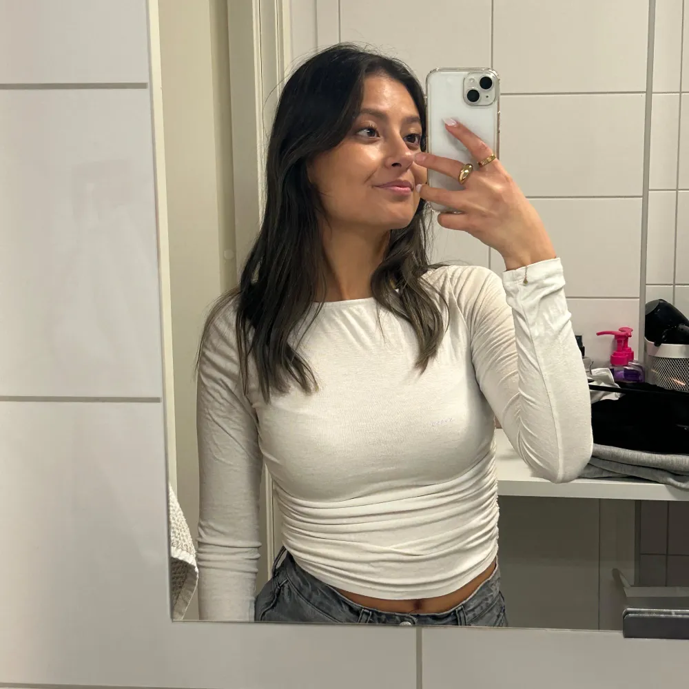 Säljer en stilren vit långärmad topp från H&M Divided. Toppen har en åtsittande passform och är tillverkad i ett mjukt material som ger en bekväm känsla. Perfekt för att matcha med jeans eller kjol. Hör av dig vid intresse!. Yläosat.