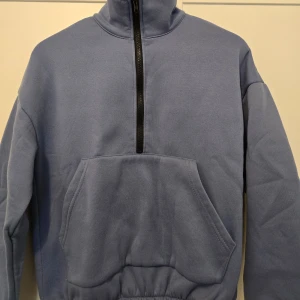 Blå och ljusgrön hoodie från SHEIN - Säljer två mysiga hoodie från SHEIN med halv dragkedja och stor ficka framtill. Perfekt för kyliga dagar med sin höga krage.