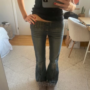 Lågmidjade jeans med nitar och snörning - Så coola lågmidjade jeans med nitar och snörning vid benen. Jättenajs tvätt och utsvängda 