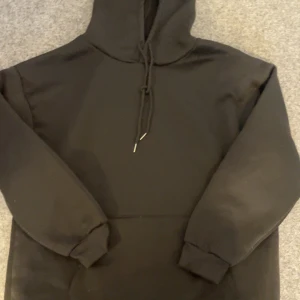 Svart hoodie med tryck - Säljer en svart hoodie med ett coolt tryck på baksidan. Trycket föreställer en dödskalle med blommor och texten 'Beautiful Crazy'. Hoodien har långa ärmar och en justerbar huva med snören. Perfekt för en avslappnad stil.