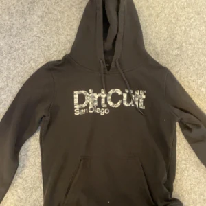 Svart hoodie från DirtCult - Säljer en svart hoodie från DirtCult. Tröjan har en klassisk design med huva och känguruficka. Perfekt för en avslappnad stil.