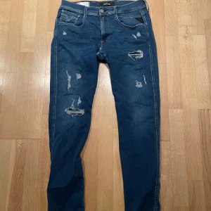 Replay jeans - Snygga blå jeans från Replay med slitna detaljer. Perfekta för en avslappnad stil. Knappt använda och säljer för ett bra pris!