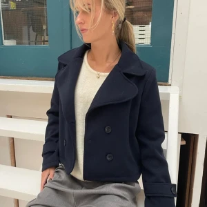 Mörkblå kappa - Jättefin mörkblå kort kappa från design by si. Använd ett fåtal gånger och är i nyskick. Säljer då den inte riktigt passar mig längre. Skriv privat för fler bilder!