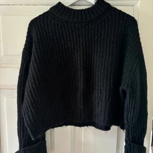 Stickad tröja - Svart stickad tröja med uppvikta ärmar, fint skick på tröjan, säljer då den inte är till användning längre.