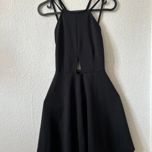 Svart klänning med öppen rygg - Fin klänning med öppen rygg. Fint skick, något stor i storleken. 