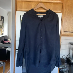 Blå linneskjorta från Cos  - Regularfit, storlek Eu 39, passar som L. Bra skick 