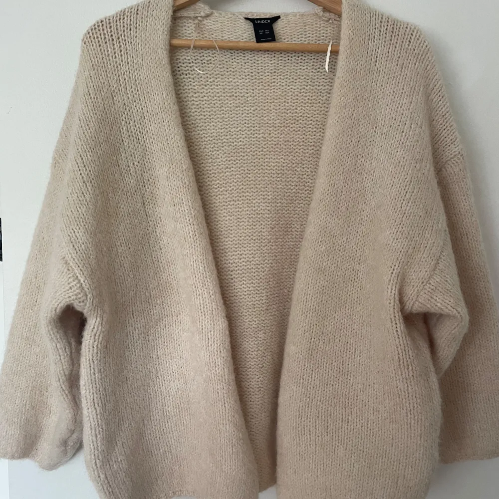 Säljer den populära lindex koftan i färgen beige och storlek M/L. Den är oanvänd bara testad med lappen har jag tagit av. Jättebra skick då jag inte använt den och den bara hängt i garderoben! Nypris var 399kr så jag säljer den för 289kr!. Tröjor & Koftor.