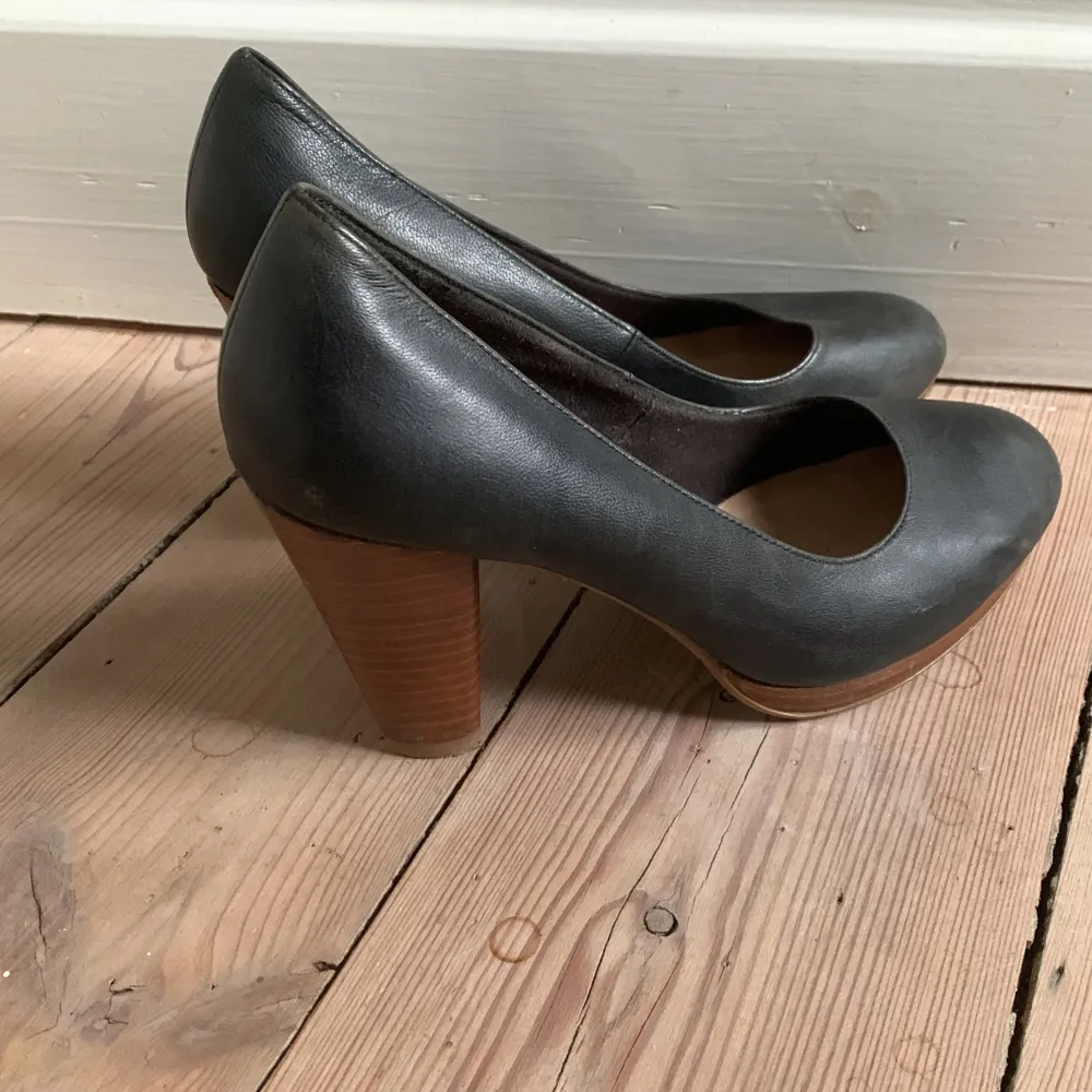 Svarta pumps i äkta skinn med brun träklack. Använda några tillfällen men bra skick.. Kengät.