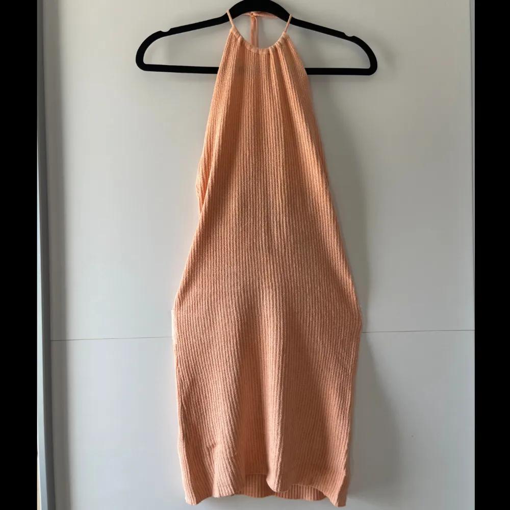 Pastell orange Bershka haltnerneck mini klänning, köpt sommaren 2023. Jag har använt den 2 gånger och den är i jätte bra skick. Stickat men tunt material, ej för varm att ha på sommaren. Obs. Kan tvättas och strykas om önskas🤗. Klänningar.