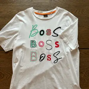 En vit t-shirt från Hugo boss med motiv i olika färger. Väldigt sparsamt använd. Storlek S men sitter som en medium. 