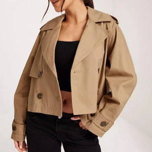 Short trench coat - Kort trench i Beige. Slutsåld överallt. Storlek S. Perfekt nu till våren och sommaren. 🌺💖 Helt oanvänd och nypris 599:-