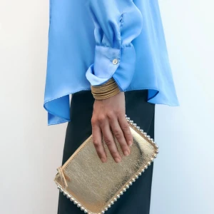 Guldig väska  - Guldig väska med pärlor, prislapp kvar och helt slutsåld på hemsidan. Har en kedja som går att ta av. 